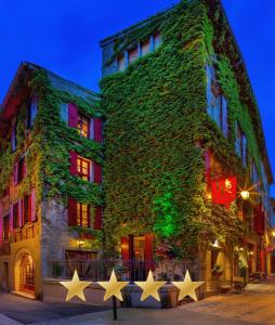 a building covered in ivy with stars in front of it at Hôtel Renaissance in Castres