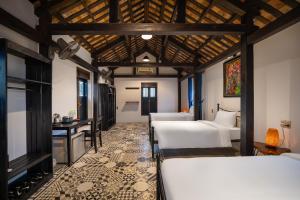 1 dormitorio con 4 camas en una habitación con techo en Calm House 3 en Hoi An