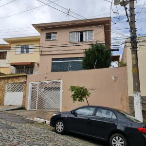 圣保罗Hostel On Top1 CGH SP QUARTO PRIVADO Congonhas的停在房子前面的一辆黑色汽车