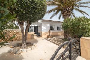 une maison avec deux palmiers devant elle dans l'établissement KASSIOPEA, à Cala Blanca