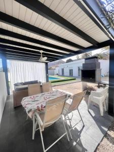 a patio with a table and chairs and a grill at Casa Mayra in Los Caparroses