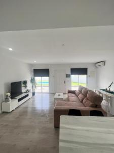 a large living room with a couch and a tv at Casa Mayra in Los Caparroses