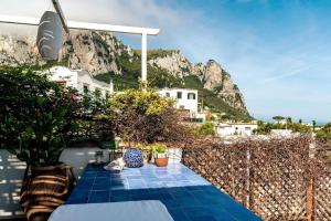 patio con piastrelle blu e montagna sullo sfondo di Casa La Scaletta, Capri a Capri