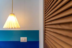 una luce appesa a una porta con persiane in legno di Casa La Scaletta, Capri a Capri