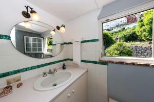 un bagno con un lavandino, uno specchio e una finestra di Casa La Scaletta, Capri a Capri Altre 26 foto