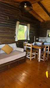a room with a bed and a table and a dining room at Piedra que late in Tandil