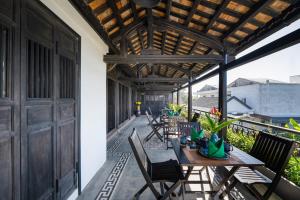 zewnętrzne patio ze stołami i krzesłami oraz drewnianym sufitem w obiekcie Calm House 3 w Hoi An