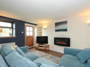a living room with a couch and a fireplace at The Bower in Helston