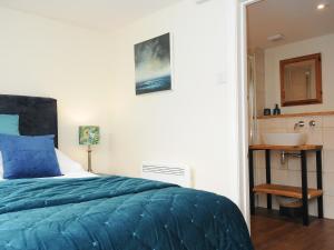 a bedroom with a bed and a sink at The Bower in Helston