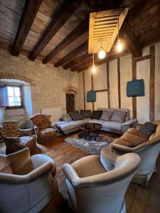 uma ampla sala de estar com sofás e cadeiras em Grand gîte 23 couchages em Lalandusse