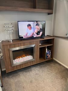 a living room with a television and a fireplace at Seton sands caravan rental in Port Seton