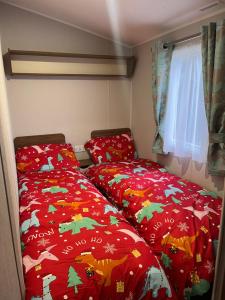 two beds in a small room with christmas blankets at Seton sands caravan rental in Port Seton