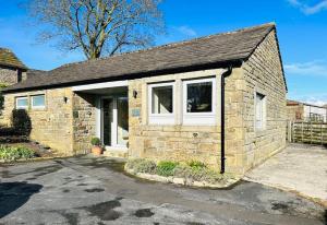 a small brick house with a white window at The Stable in The Dales in Silsden