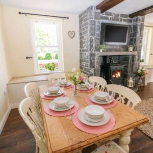 a dining room table with chairs and a fireplace at Shannonvale Cottage in Nenagh