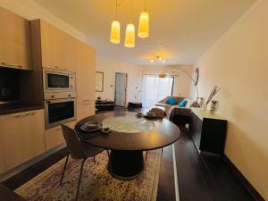 eine Küche und ein Wohnzimmer mit einem Tisch und einem Sofa in der Unterkunft R2 Salina Seaview Retreat in Naxxar