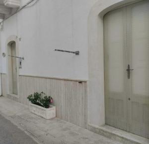 un edificio con una puerta y una maceta en L 'Alcova Holidays Home CENTRO STORICO, en Ceglie Messapica