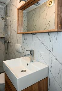 bagno con lavandino bianco e specchio di Porto Azzurro apartments a Tivat