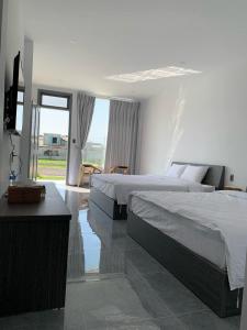 Ấp Lò GốmにあるSea Breeze Homestay - Phước Hảiのベッド2台と薄型テレビ付きのベッドルーム