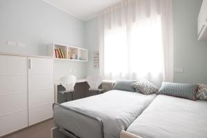 a bedroom with two beds and a desk and a window at Casa Cate Cervia Centralissima in Cervia +43 photos