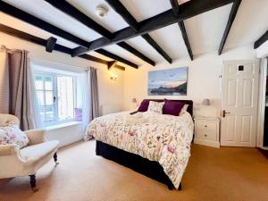 um quarto com uma cama e uma cadeira em The Cottage Bed & Breakfast em Polperro