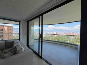 een woonkamer met een bank en grote ramen bij 1401, Luxury Penthouse In El Poblado in Medellín