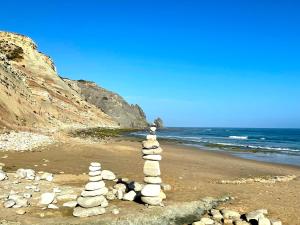a stack of rocks on a beach near the ocean at Beautiful sea view in Luz