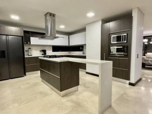 een keuken met een wit aanrecht en zwarte kasten bij 1401, Luxury Penthouse In El Poblado in Medellín