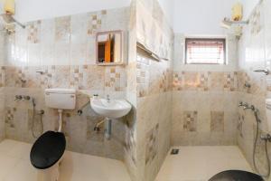 a bathroom with a sink and a toilet at Ritzy Village Residency in Cochin