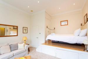 a bedroom with a bed and a couch at Charming Studio Apartment Near Clapham Common in London