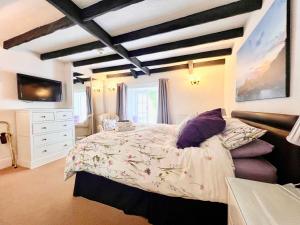 um quarto com uma cama grande e uma cómoda branca em The Cottage Bed & Breakfast em Polperro