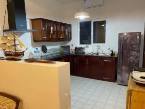 - une cuisine avec des placards en bois et un comptoir dans l'établissement Air conditioned 3 bed home!, à Nugegoda