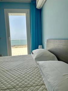 um quarto com uma cama e uma porta para uma praia em SIGISHOUSE em Fiumicino