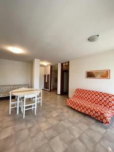 Sala de estar con cama y mesa en Residence Luna en Lignano Sabbiadoro