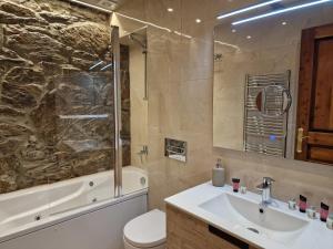 een badkamer met een wastafel, een bad en een toilet bij Apartamento típico a 3 min a pie del telecabina in El Tarter