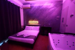 a purple room with a bed and a bath tub at Cleopatra in Rome