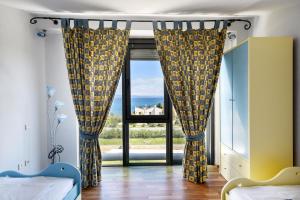 Un dormitorio con un gran ventanal con vista al mar. en VILLAGE CLUB 27, en Nea Fokea 36 fotos más