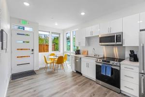 a kitchen with white cabinets and a table with chairs at Martell's Sunspear Sweet Suite in Seattle