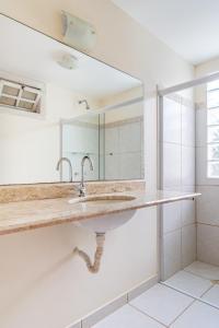 a bathroom with a sink and a mirror at Vista panorâmica e praia a pé. in Búzios