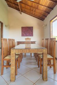 uma sala de jantar com uma mesa de madeira e cadeiras em Vista panorâmica e praia a pé. em Búzios