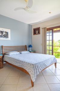 a bedroom with a bed with a blue comforter at Vista panorâmica e praia a pé. in Búzios