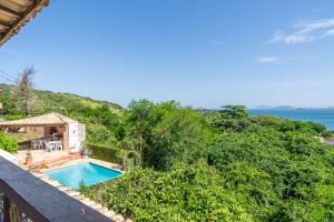 a villa with a swimming pool and the ocean at Vista panorâmica e praia a pé. in Búzios