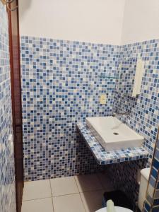 a blue tiled bathroom with a sink and a toilet at Jeri Kite Surf Hostel in Jericoacoara