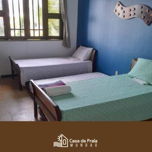 een kamer met 2 bedden en een blauwe muur bij Casa de Praia em Mundaú in Mundaú