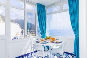 ポジターノにあるCasa Aurora Positanoのテーブルと椅子と窓のあるダイニングルーム