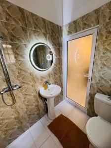 een badkamer met een douche, een toilet en een wastafel bij AD HOME in Lomé