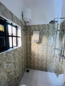 a bathroom with a shower and a toilet and a window at AD HOME in Lomé +30 photos