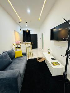 een woonkamer met een bank en een tv bij AD HOME in Lomé