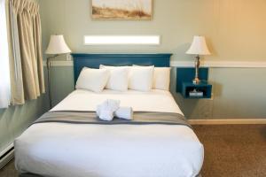 a bedroom with a large bed with two towels on it at The Janmere Motel in Hampton