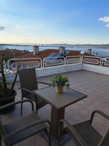 eine Terrasse mit einem Tisch, Stühlen und einem Boot in der Unterkunft The White House in Nessebar