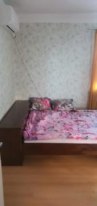 Къща за гости في Razgrad: سرير بملاءات ومخدات وردية في الغرفة